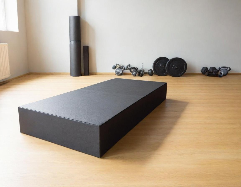 A black rectangular platform on a wooden floor in a gym setting.